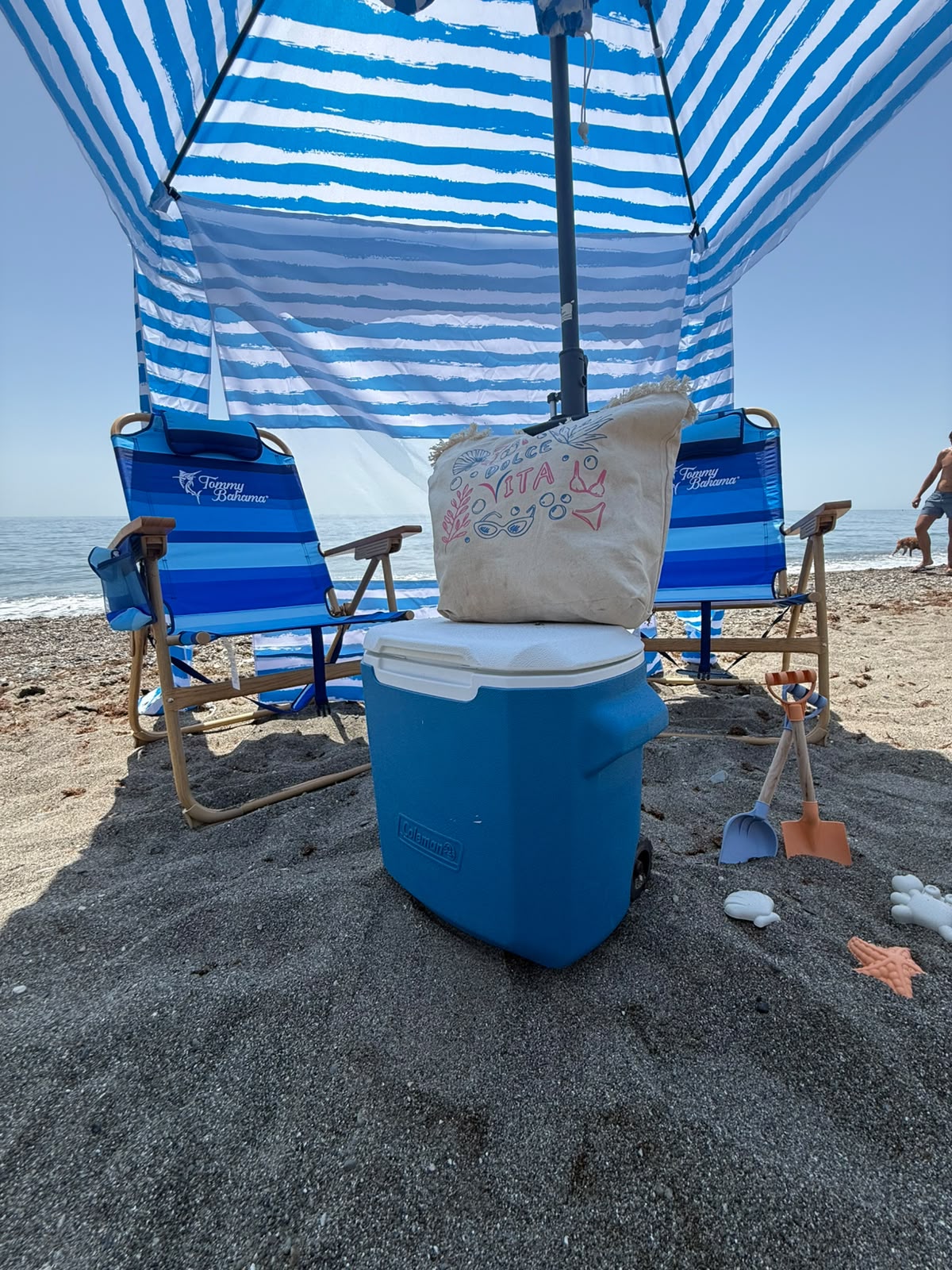 Beach cabana with Tommy Bahama chairs and a cooler, set up on the sand